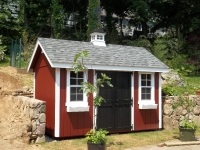 8' x 12' New England Elite with red body, white trim, black doors, charcoal roof optional dutch doors, garden vents, vinyl flower boxes, cupola window, weathervane