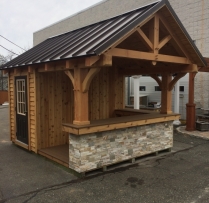 10x12 Siesta with cedar siding, Timberframe overhang and rafters, Standing seam metal roof, custom stonework on L shaped bar and a 2
